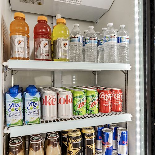 A refrigerator with various beverages including sports drinks, bottled water, coconut water, soft drinks, coffee drinks, and energy drinks.